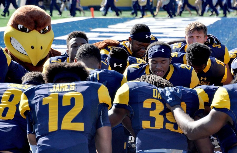 Kent Sate running back Will Matthews (center right) leads a short prayer just after the national anthem to start off their game versus Buffalo on Saturday, Sept. 30, 2017.