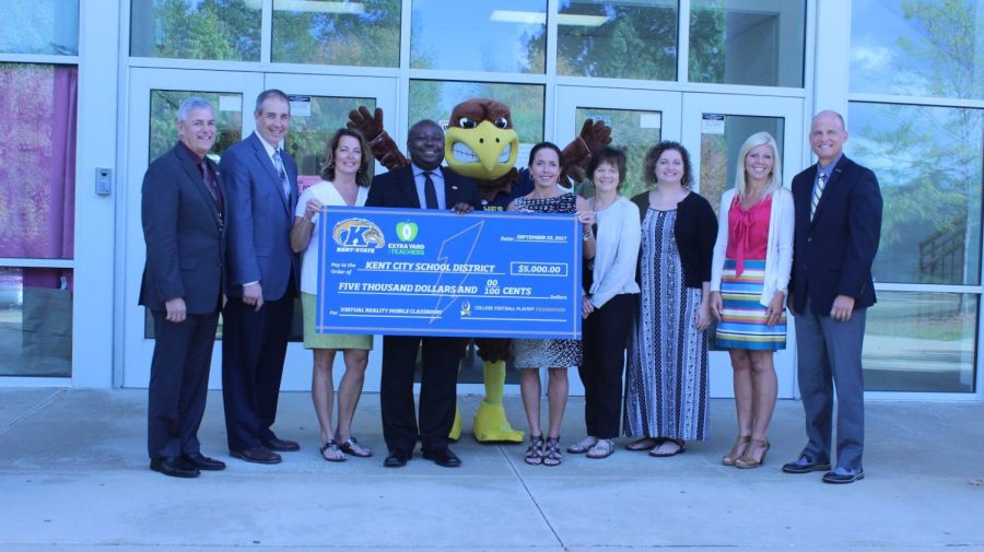 Kent State and Kent City Schools employees, including Kent City Schools superintendent George Joseph (left) and Kent State Director of Athletics Joel Nielsen (right), pose with the $5,000 grant check for an upcoming virtual reality project.