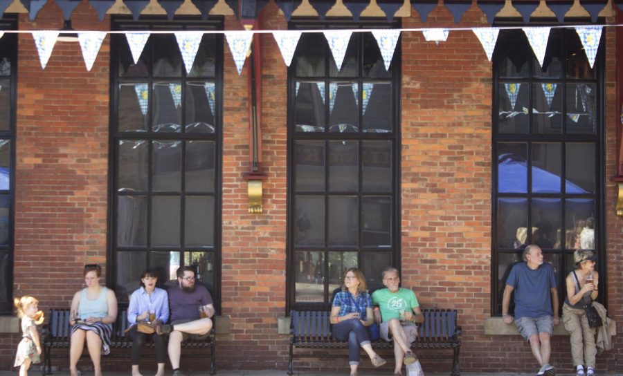 Festival-goers sit outside Treno Ristorante in downtown Kent during Oktoberfest on Saturday, Sept. 23, 2017.