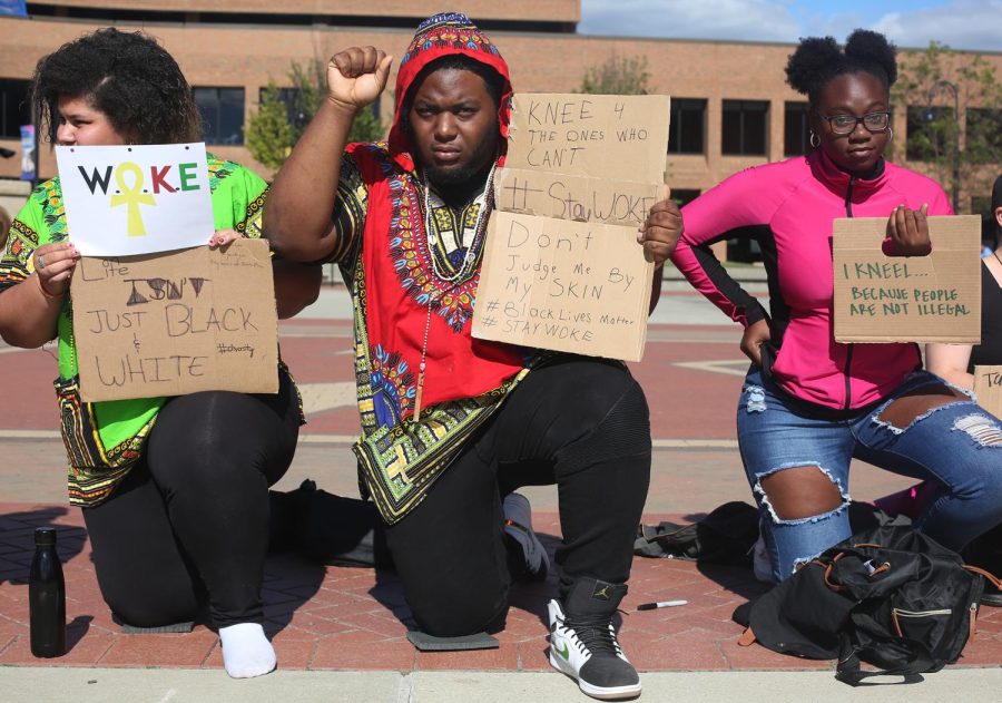 Suleika Carlo-Ramos (left), a sophomore biology major, Richard Gibson and Taniyahh Lennon, both sophomore psychology majors, participate in the "Take a Knee" demonstration in Risman Plaza Thursday, Sept. 28, 2017. 