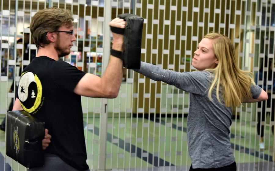 Lauren Dangel, a freshman communication studies major, hits Brian Bowles using the technique he taught those in attendance of the self-defense class.