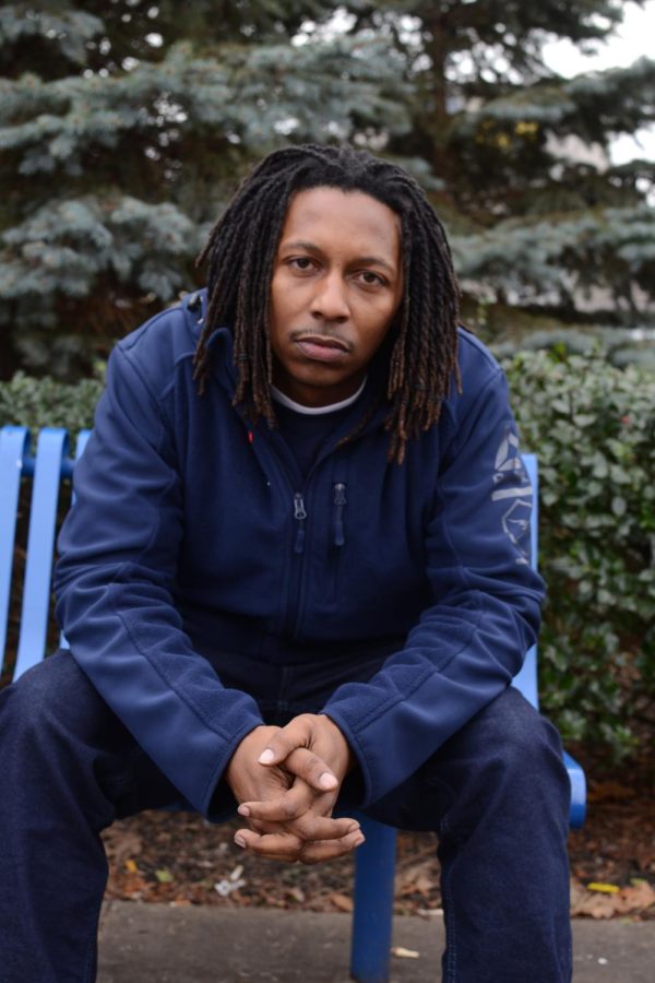 Business management major Chris Coteat poses on a bench outside of a McDonald's restaurant in Akron Wednesday, Dec. 6, 2017.