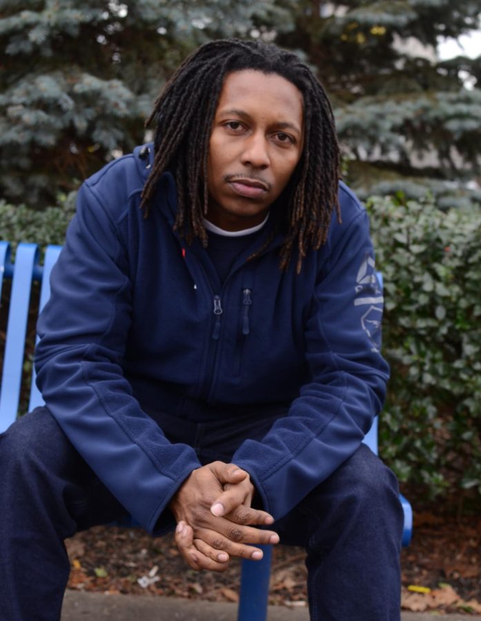 Chris Coteat poses on a bench outside of a McDonald's restaurant in Akron on December 6, 2017.