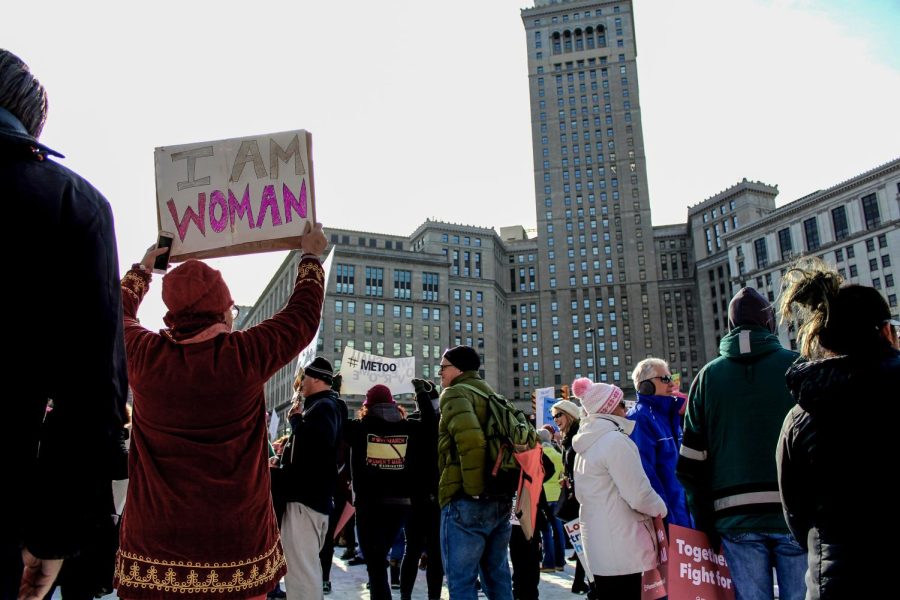 A woman stands among the crowd with an “I AM WOMAN” sign during the Women’s March in Cleveland's Public Square.