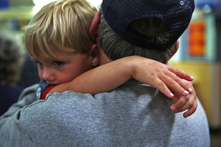 John Bowman's 8-year-old grandson, Caidean, hugs him while waiting in a line at a Walmart Pharmacy in Rowan County.