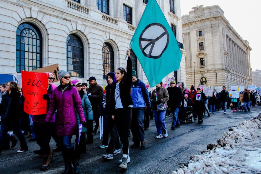 The crowd marches through the streets of Cleveland as they lift flags and signs during the Women's March Jan. 20, 2018.