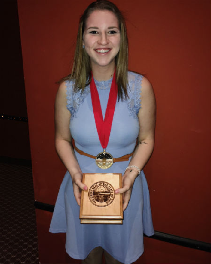 Nina Schubert stands with her courage award given to her by John Kasich. 