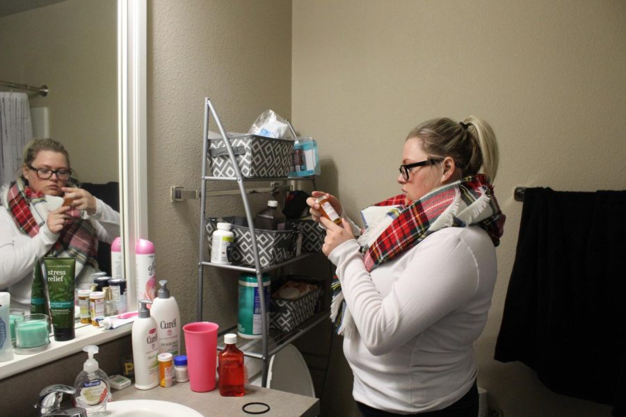 Brooke Estridge checks her medicine in her apartment on March 1, 2018. 