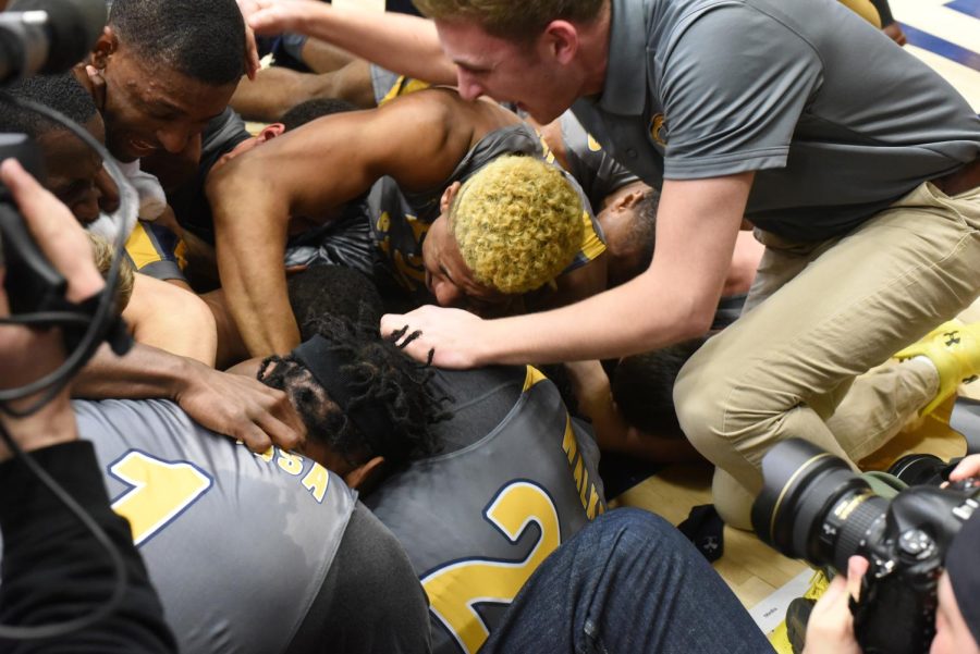 Kevin Zabo's teammates pile on top of him after he scored the game-winning basket on March 5, 2018. The Flashes won, 61-59, in the first round of the Mid-American Conference tournament.