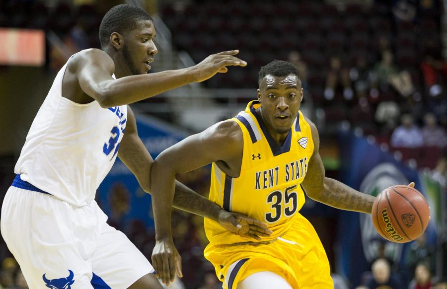 Kent State senior forward Jimmy Hall drives against Buffalo red-shirt senior forward Raheem Johnson during the quarter-finals of the MAC Tournament at Quicken Loans in Cleveland, Ohio. Kent State won, 68-65.