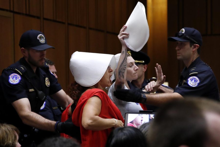 Protesters of President Donald Trump's Supreme Court nominee, Brett Kavanaugh, protest while wearing costumes from the show "The Handmaid's Tale," during his confirmation hearing with the Senate Judiciary Committee on Capitol Hill in Washington, Wednesday, Sept. 5, 2018, during the second day of the confirmation hearing to replace retired Justice Anthony Kennedy. (AP Photo/Jacquelyn Martin)