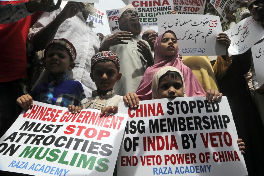 Indian Muslims participate in a protest against the Chinese government, in Mumbai, India, Friday, Sept. 14, 2018. Nearly 150 Indian Muslims held a street protest in Mumbai, India's financial capital, demanding that China stop detaining thousands of members of minority Uighur Muslim ethnic group in detention and political indoctrination centers in Xinjiang region. Placard reads "Chinese government must stop atrocities on Muslims." (AP Photo/Rajanish Kakade)