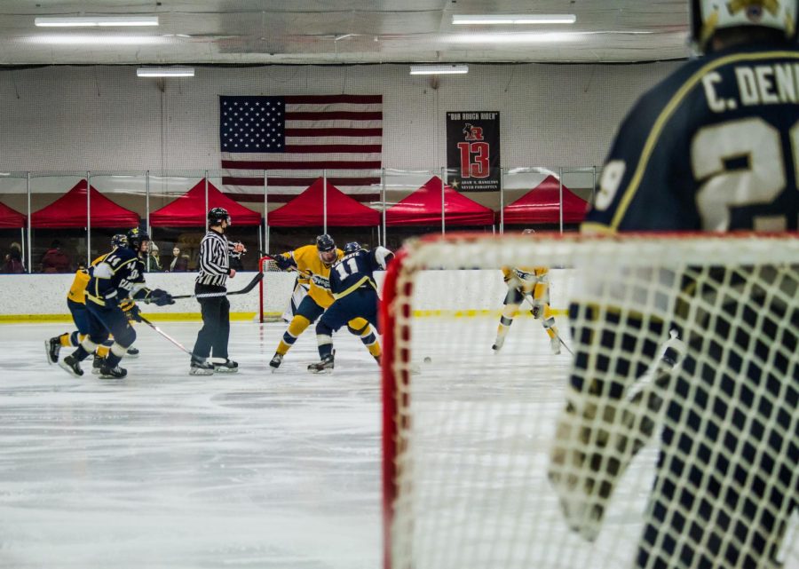 Kent State and John Carroll battle for a faceoff as Lobos goaltender Charlie Denner looks on. The Flashes won the game, 9-2. 