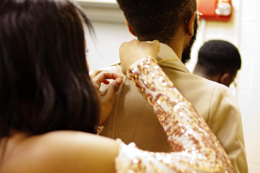 Taminique Blackwell assists Manny Jackson in putting on his chain backstage during the formal wear portion of the Renaissance Ball on Nov. 8, 2018.