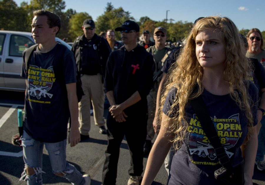 Kaitlin Bennett, the organizer of an open-carry walk on Kent State's main campus, walks back to her car with her personal security detail at the end of the walk on Sept. 29, 2018.