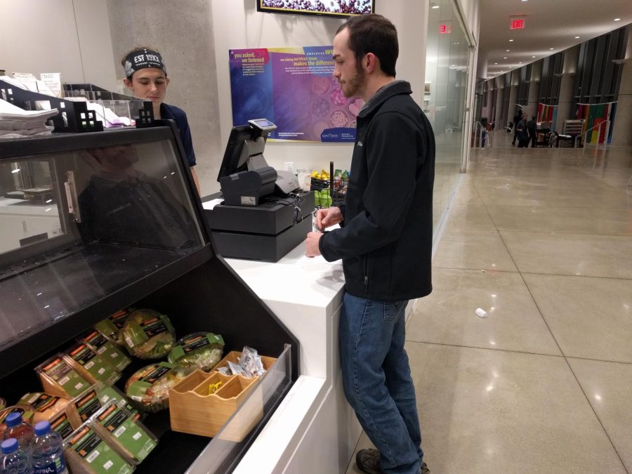 Sophomore architecture major Caleb O'Bryon uses his meal plan to purchase food at the George T. Simon III Cafe on Wednesday, November 14.