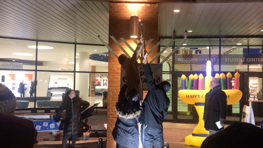 Kent State President Beverly Warren lights the shamash on the nine-foot-tall menorah on December 3, 2018.