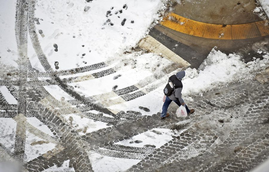 A pedestrian walks across the street in downtown Scranton, Pa., on Sunday, Jan. 20, 2019. A major winter storm brought some of the coldest temperatures of the season and covered a large swath of the country in snow as it wreaked havoc on air travel and caused slick road conditions throughout New England Sunday. (Butch Comegys/The Times-Tribune via AP)