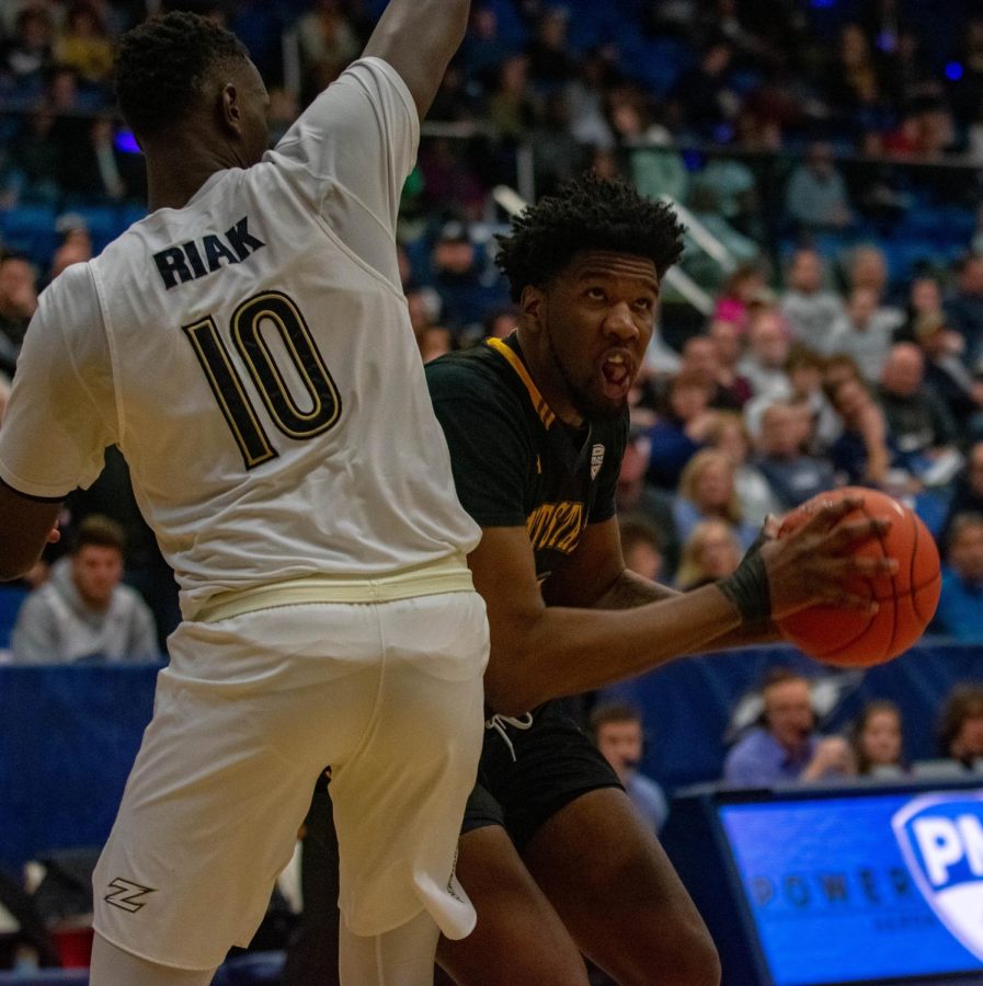 Philip Whittington makes a play around Akron defense during the Friday night matchup between Kent State University and the University of Akron. The Flashes lost 72-53.