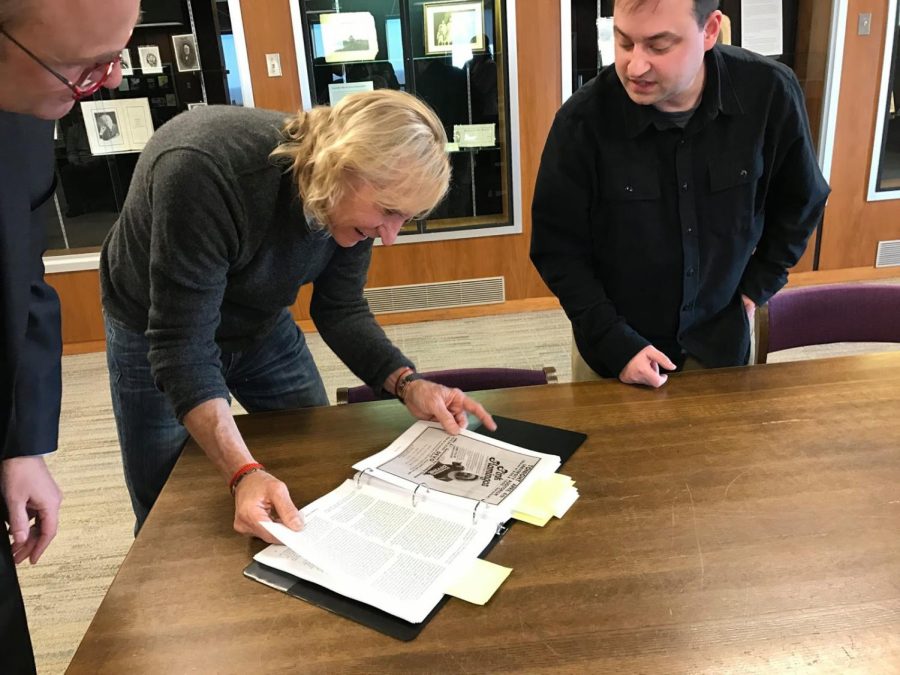 Kent State Provost Todd Diacon, Joe Walsh of The Eagles and Jason Prufer looking at a manuscript of "Small Town, Big Music" on the 12th floor of the KSU library.