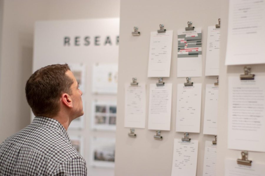 Grant Fletcher, an adjunct visual communication design professor, looks at "Emerge" poems created by visitors of the "Traveling Stanzas" exhibit in Taylor Hall on Wednesday, Feb. 7, 2019.