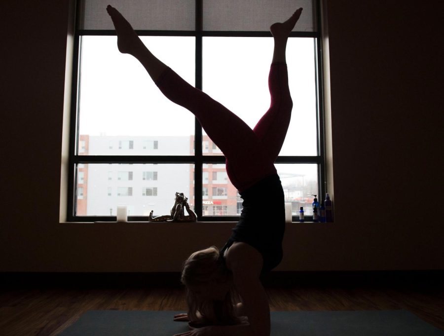 Kent State alumni Allison Yanci practices yoga downtown at One Love Yoga Boutique on Tuesday, Jan. 31, 2017. “There’s a lot more benefits than just relaxing and stretching,” said Allision. “I study the spiritual side of it, but I love a sweaty power class too.”