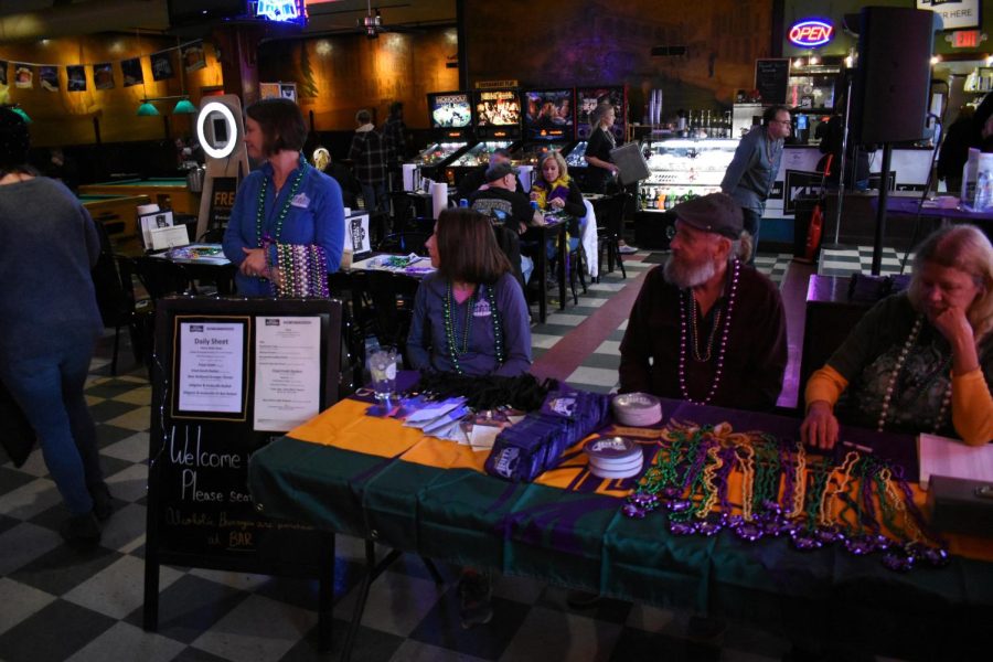 A desk covered in beads and passes for the Mardi Crawl event are ready for patrons at the Venice Cafe March 2, 2019.