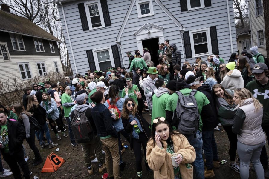 Partygoers stand outside a house on University Drive during this year's annual Fake Paddy's Day celebration in Kent.