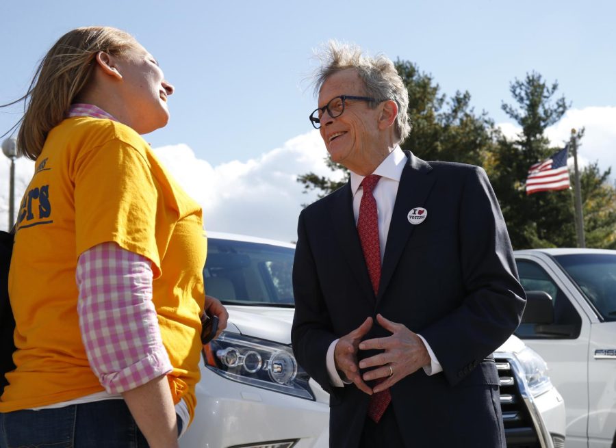 Ohio Governor Mike DeWine, right, greets a voter outside the Green Township Senior Center, a voting precinct, Tuesday, Nov. 6, 2018, in Cincinnati, Ohio. (AP Photo/Gary Landers)