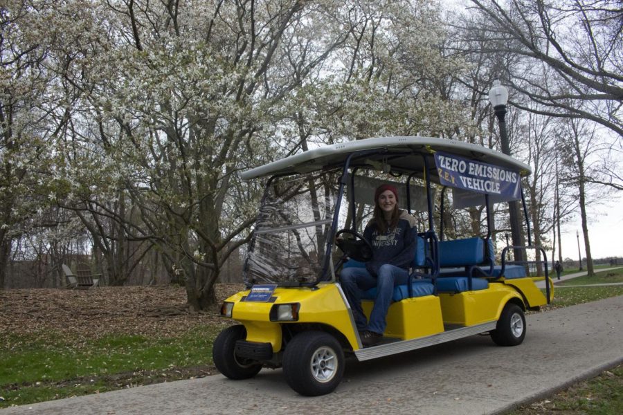 Angela Deibel, a senior double majoring in marketing and engineering, sits in the zero emissions vehicle on Monday, April 22, 2019, near trees outside of Henderson Hall. 