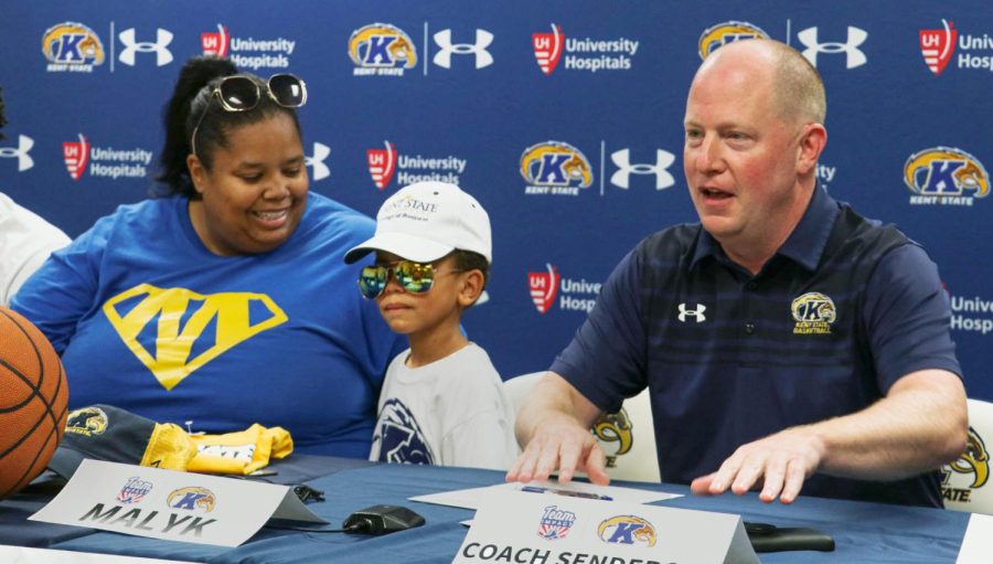 Coach Rob Senderoff (right) welcomes Malyk Foster to the Kent State Golden Flashes basketball team while Danielle, Malyk's mom, smiles with pride in the Kent State Mac Center on Aug. 26, 2019.