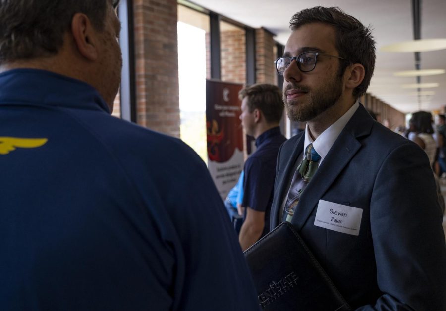 Junior digital sciences major Steven Zajac speaks with a representative from Goodyear Tire at the IS/IT Meet &amp; Greet on Wednesday, September 11, 2019.