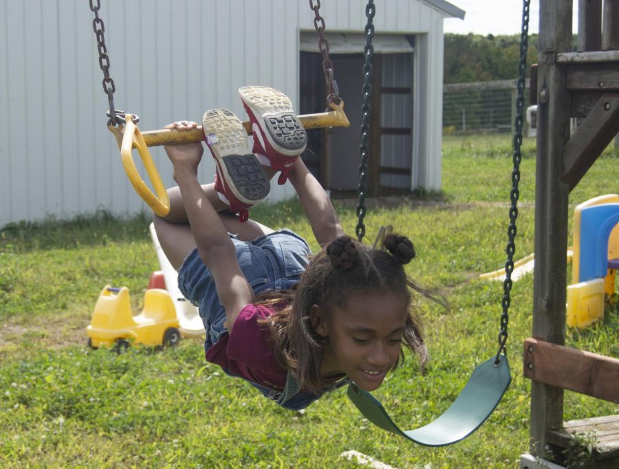 Nyla hangs on bar on the playground at Sand Hill Stable in Mantua, Ohio. Nyla and her mentor Michele play on the playground when they visit the stable Saturday, September 14, 2019.