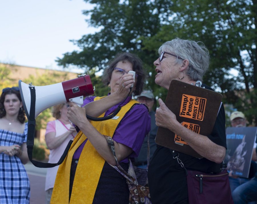 Reverend Renne Zimelis-Ruchotzke holds the microphone for Cheryl Lessin as she tells the crowd about a non-violent protest in Washington D.C. that will push against what she called the "fascist regime" of President Donald Trump at the climate strike held at Risman Plaza on Sept. 20, 2019. She said the "regime" is one of the biggest factors in climate change. 