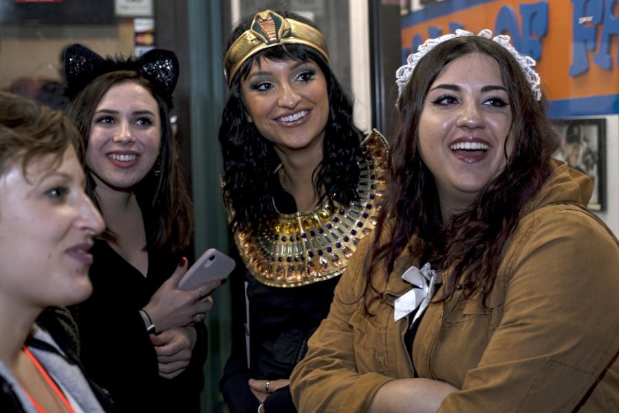 (From left to right) Maggie Schwabenbauer, Dina Restifo, Bri Ward, and Julia Bilotta stand under the awning in front of Guy's Pizza to avoid the rain early Sunday, Oct. 27, 2019. 