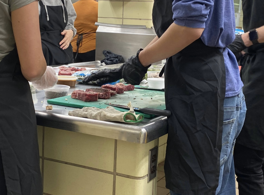 Students prepare cuts of steak to pair with different wines at the end of class on Oct. 15, 2019. 