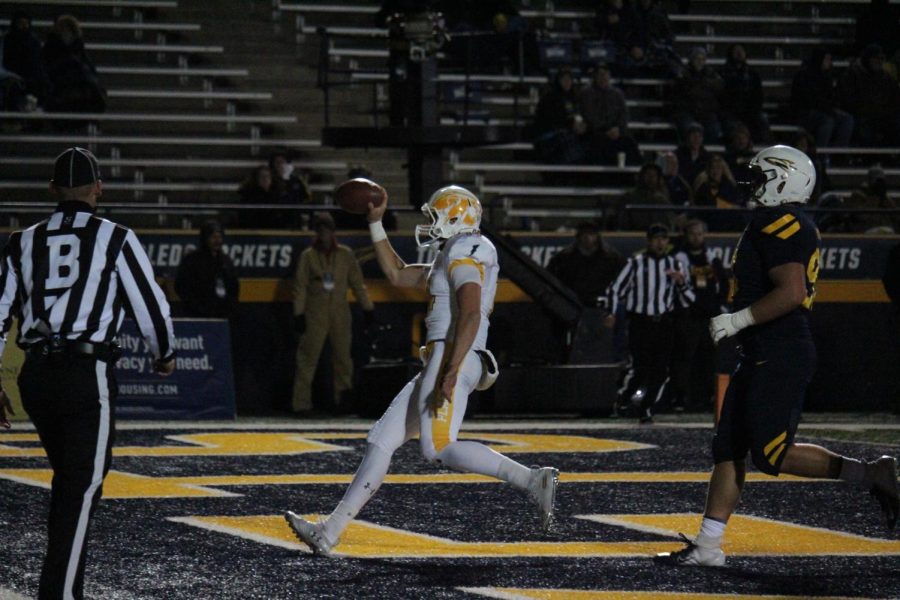 Junior quarterback Dustin Crum (14) runs for the 11-yard touchdown to cut the Toledo lead to 28-27 with under two minutes left in the third quarter. 