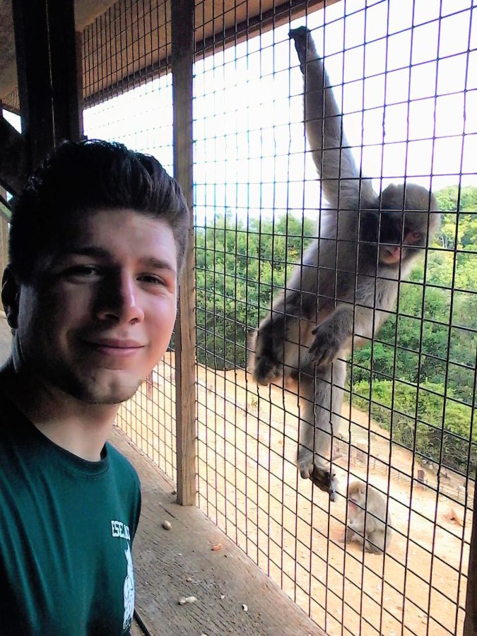 Cody Ruiz poses next to a Japanese macaque, also known as the snow monkey, in the summer of 2016. The institute researches and cares for two colonies of macaques.