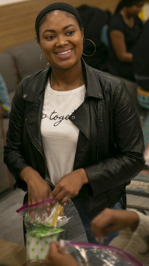 Senior fashion merchandising major Tyshaia Earnest packs period products into care packages for those in need at the Period Packing Party on Tues., Jan. 28. Earnest organized the event, provided supplies for the packages and snacks for volunteers. 