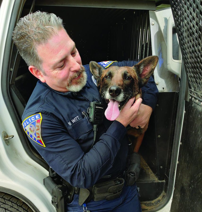 Officer Miguel Witt and his Belgian Malinois, Dexter, sit in the back seat of Witt's K9 unit.