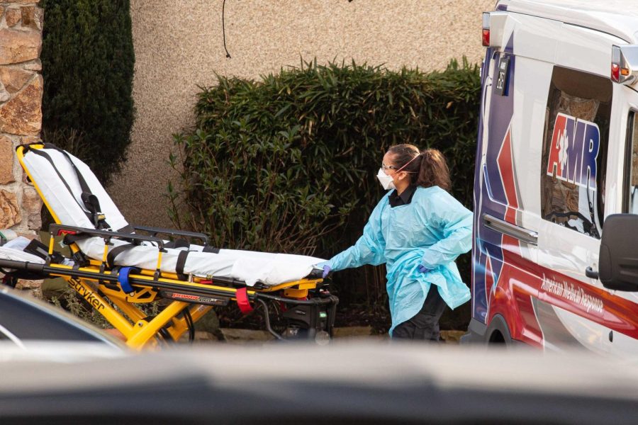 SEATTLE, WA - FEBRUARY 29: A healthcare worker prepares to transport a patient on a stretcher into an ambulance at Life Care Center of Kirkland on February 29, 2020 in Kirkland, Washington. Dozens of staff and residents at Life Care Center of Kirkland are reportedly exhibiting coronavirus-like symptoms, with two confirmed cases of (COVID-19) associated with the nursing facility reported so far. (Photo by David Ryder/Getty Images)