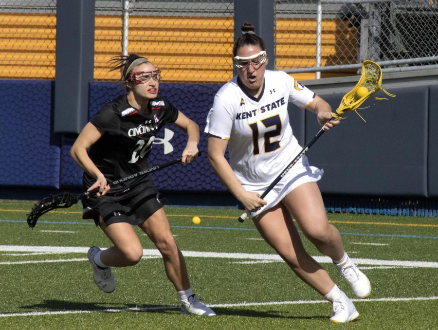 Freshman attacker Morgan Kubicki [12] cradles the ball during the women’s lacrosse game on Mar. 8, 2020 against University of Cincinnati. Kent State University lost 8-25.