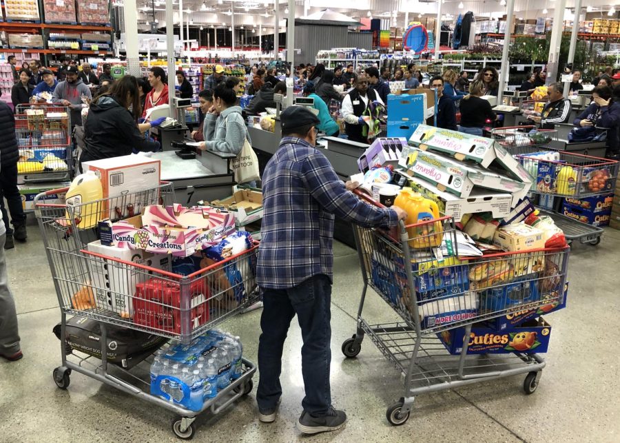 RICHMOND, CALIFORNIA - MARCH 13: A Costco customer stands by his two shopping carts at a Costco store on March 13, 2020 in Richmond, California. Some Americans are stocking up on food, toilet paper, water and other items after the World Health Organization (WHO) declared Coronavirus (COVID-19) a pandemic. (Photo by Justin Sullivan/Getty Images)