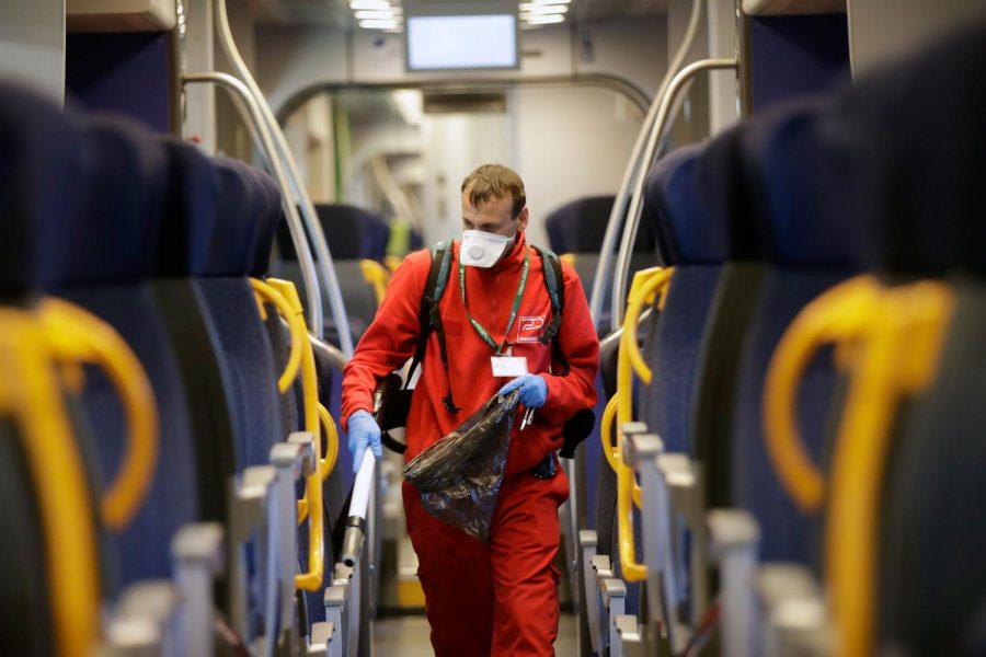 A cleaner sanitizes a wagon on a regional train at the Garibaldi train station in Milan, Italy, Friday, Feb. 28, 2020. Authorities are taking new measures to sanitize trains and public transportation after the COVID-19 virus outbreak. (AP Photo/Luca Bruno)