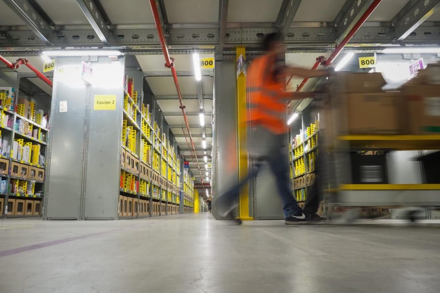 A worker walk in the Amazon's distribution center of Saran on October 26, 2018, central France. (Photo by GUILLAUME SOUVANT / AFP) (Photo credit should read GUILLAUME SOUVANT/AFP/Getty Images)