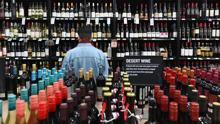 A patron stands in front of a shelf full of wine bottles at The Liquor Store.Com on March 20, 2020 in the Brooklyn borough of New York. - Liquor sales have exploded in New York since a national emergency was declared and New York closed all its theatres, bars and restaurants, while virtual cocktail parties with "quarantinis" are on the rise. (Photo by Angela Weiss / AFP) (Photo by ANGELA WEISS/AFP via Getty Images)