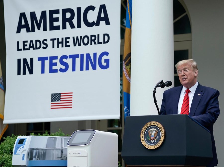 U.S. President Donald Trump, flanked by tables holding testing supplies and machines, speaks during a press briefing about coronavirus testing in the Rose Garden of the White House.