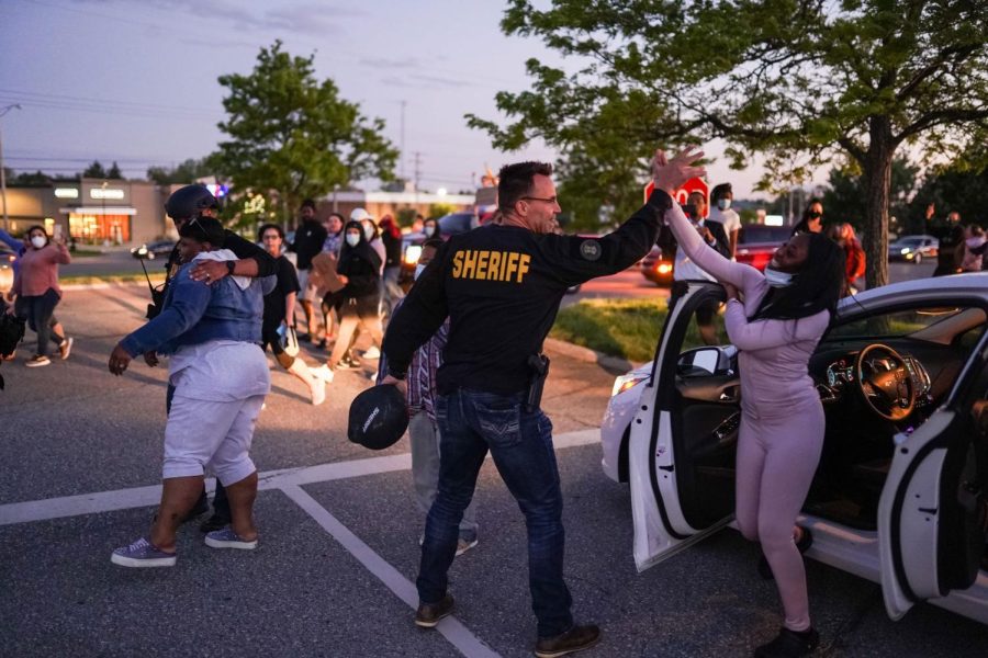 Genesee County Sheriff Chris Swanson high fives a woman who called his name Saturday.