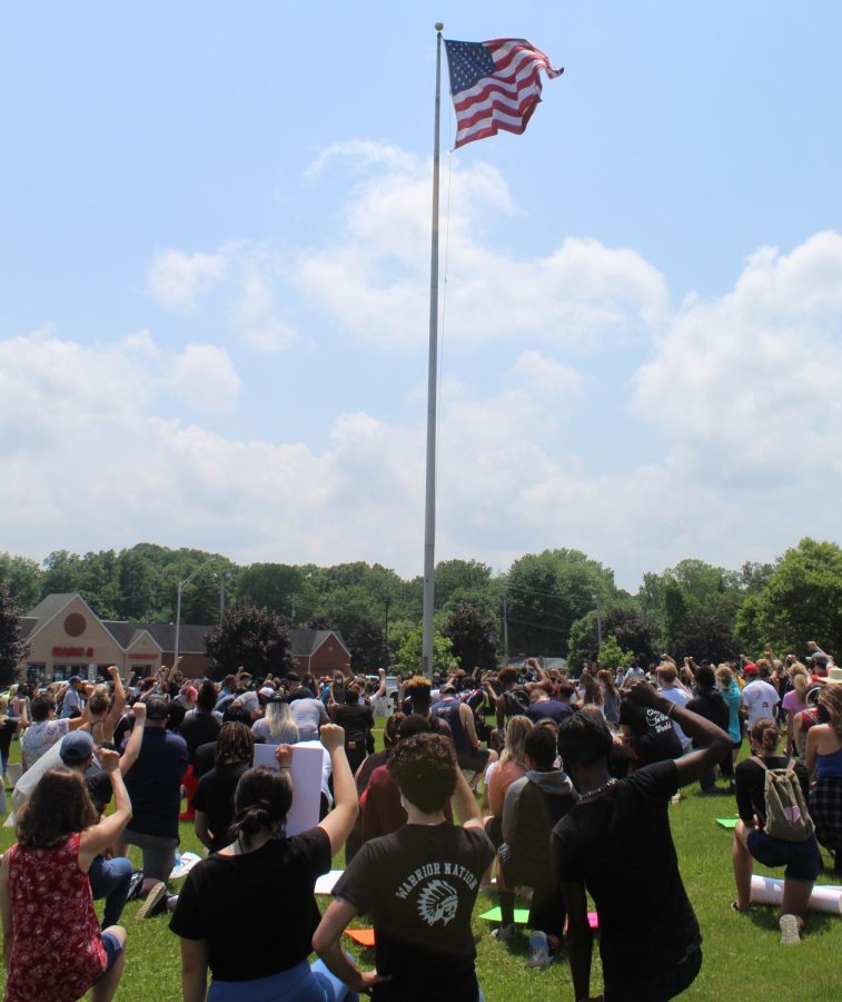 Protesters kneel in silence for eight minutes and forty-six seconds before the American flag at Stow City Hall. 