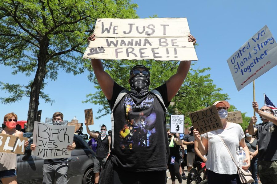 Chad Payne of Akron holds up a sign as he stands in the middle of S. High St. in downtown Akron during a protest march to end police brutality on June 6, 2020.